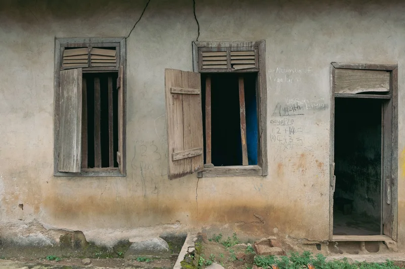 Two windows and an open doorway, chalk sums written on the wall